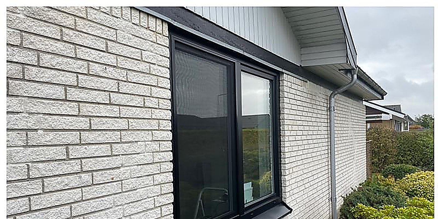 Mørkt vindue på hvid mursten